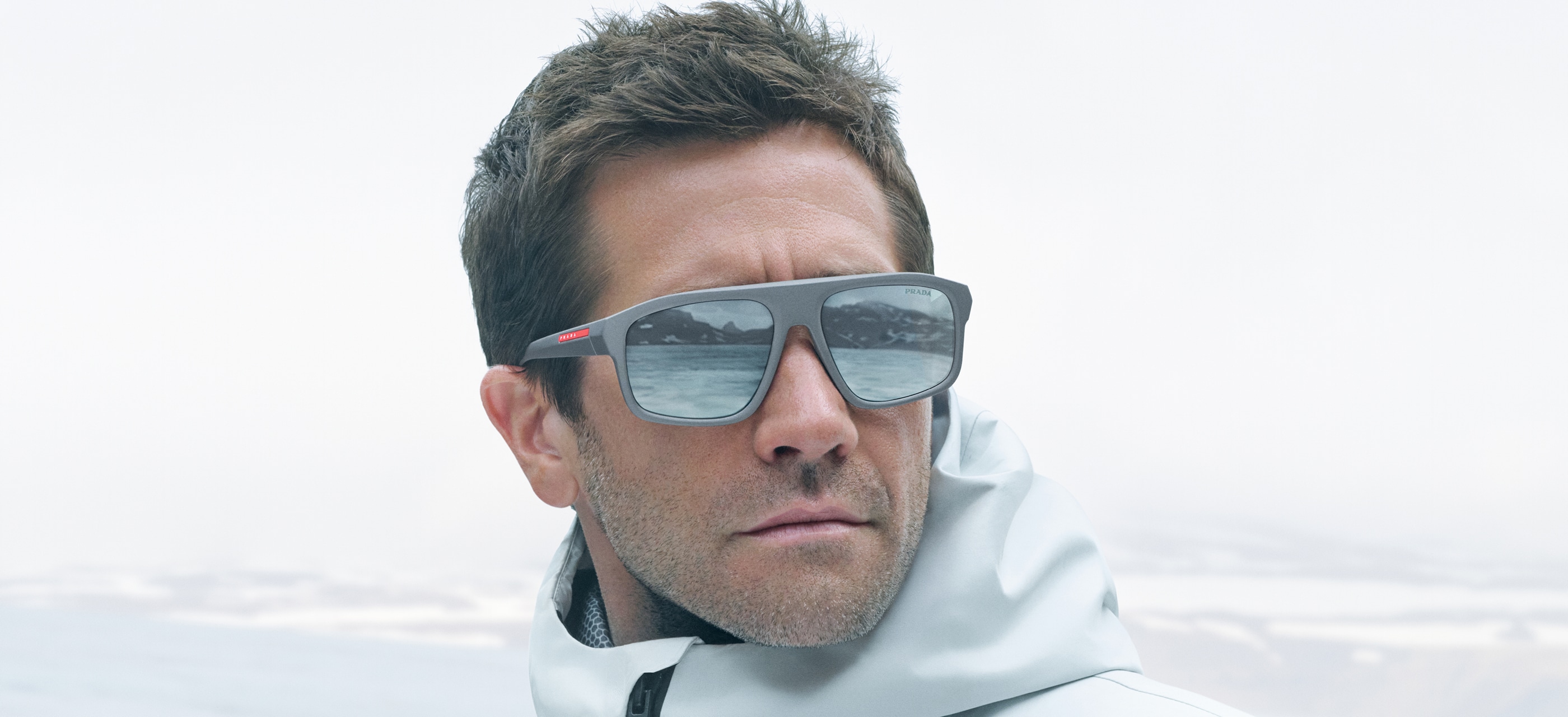 Campanha oficial Prada Linea Rossa com óculos solares cinza e lentes espelhadas